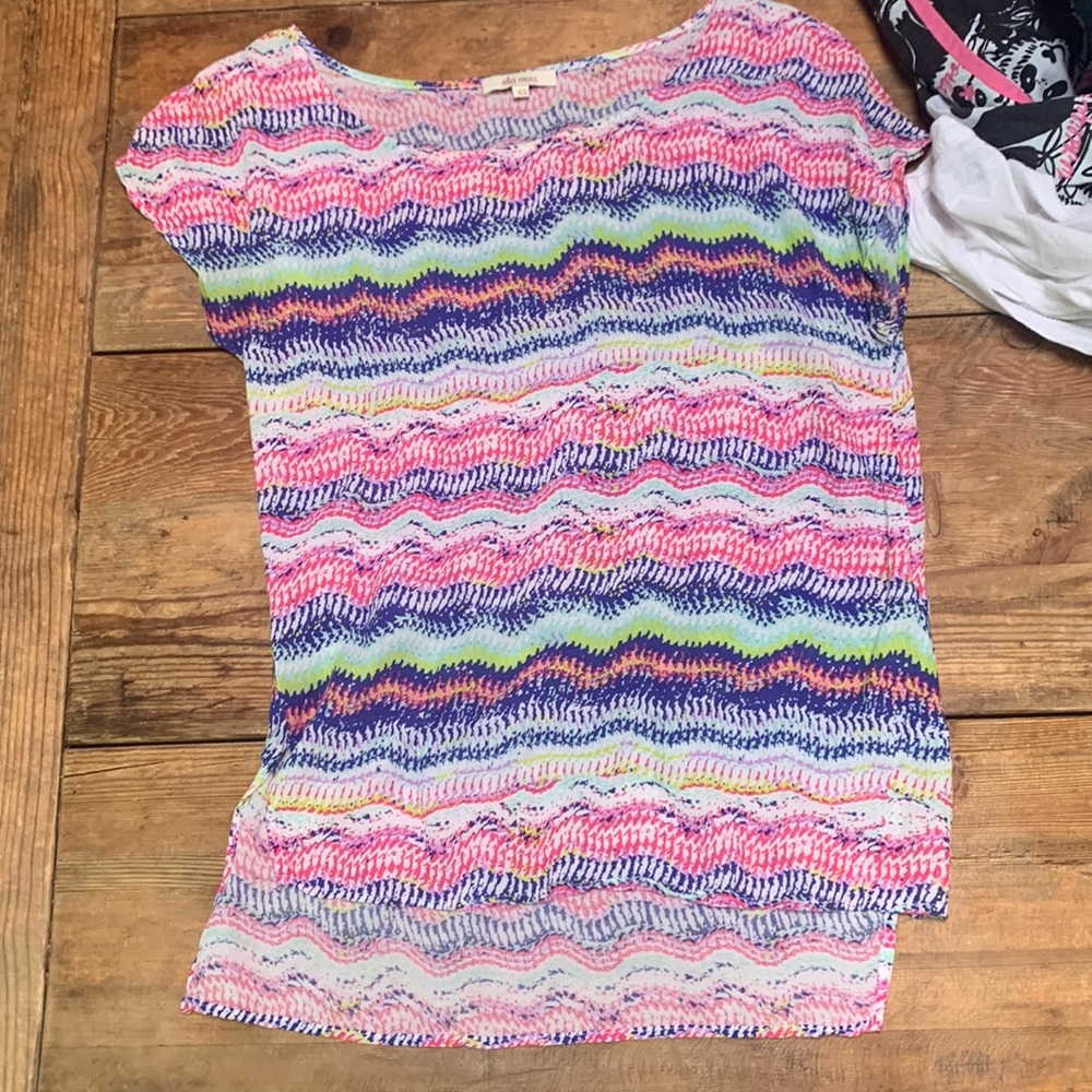 A very colorful short sleeve shirt, short in the front long in the back